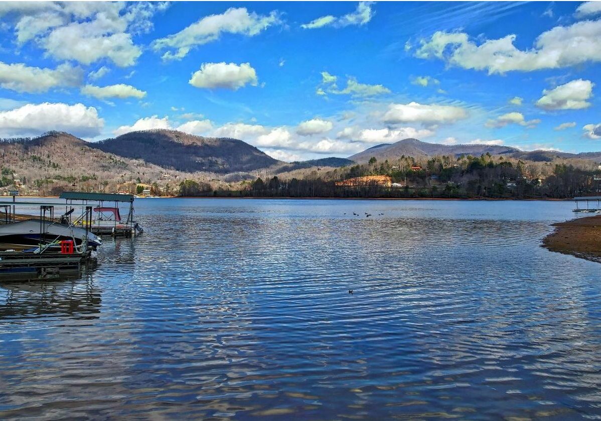 A dock on the water with mountains in the background.